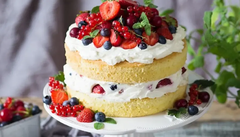 Puszysty tort z bitą śmietaną i owocami leśnymi, idealny na letnie przyjęcie. Ten przepis na tort zachwyci każdego!