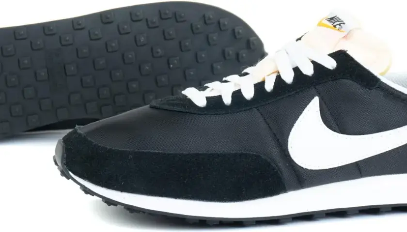 Czarne buty sportowe Nike z białym logo i sznurówkami. To pierwsze buty Nike, które zapoczątkowały legendę.