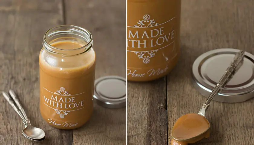Un frasco de dulce de leche casero, con una cuchara llena de esta delicia dorada.