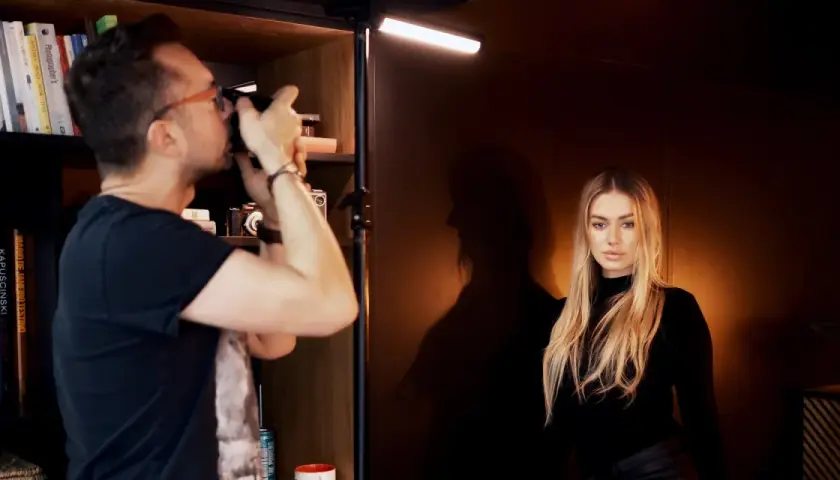 Fotograf robi zdjęcie modelce, tworząc idealne podświetlenie obrazu.