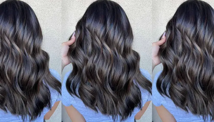 Cabello castaño oscuro con reflejos cenizos y ondas suaves.