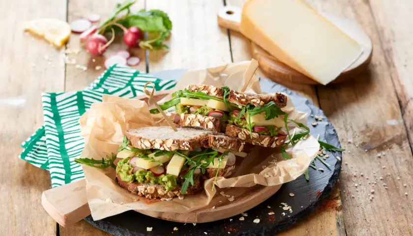 Une idée de sandwich gourmande : pain aux céréales, avocat, fromage, radis et roquette. Parfait pour un repas sain et savoureux.