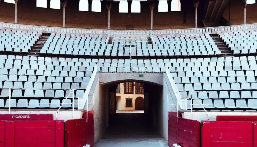 Tendidos vacíos en la plaza de toros de Las Ventas, con el plano de asientos visible y barreras rojas de picadores.