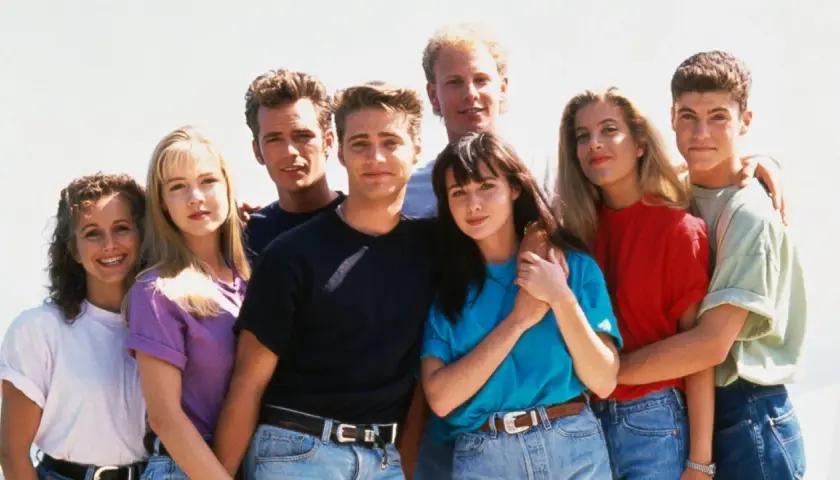 En grupp unga vänner poserar glatt, en ikonisk bild från tv-serier 90-talet.