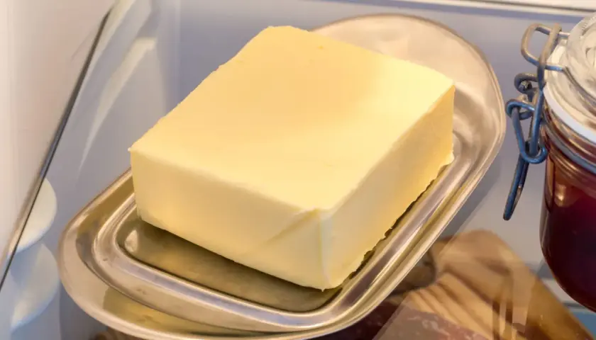 Ein Block Butter auf einem Butterfass im Kühlschrank. Die Frage "wie lange kann man Butter einfrieren?" beschäftigt viele.
