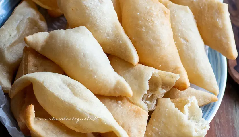 Un piatto colmo di gnocco fritto, dorato e croccante, pronto per essere gustato. La ricetta perfetta per un aperitivo sfizioso.