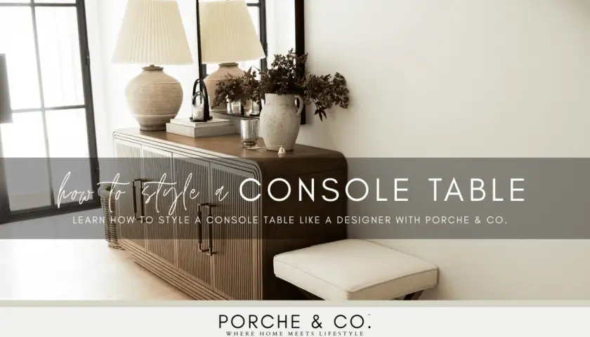 Learn how to style a console table with this designer guide. The image shows a beautifully styled console table with lamps, books, and a vase of flowers.