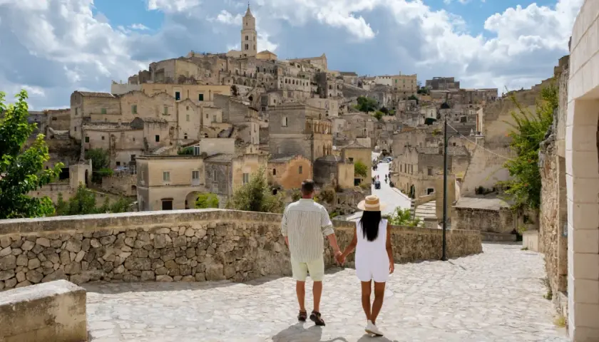 A couple walks through a historic Italian town, a perfect place to base yourself in Puglia.