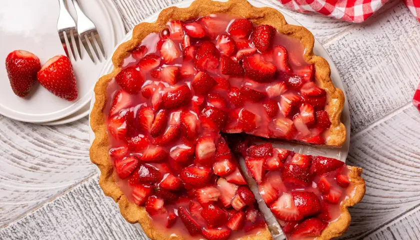 Une part de tarte aux fraises de grand-mère, garnie de fruits frais et de glaçage brillant, prête à être dégustée.