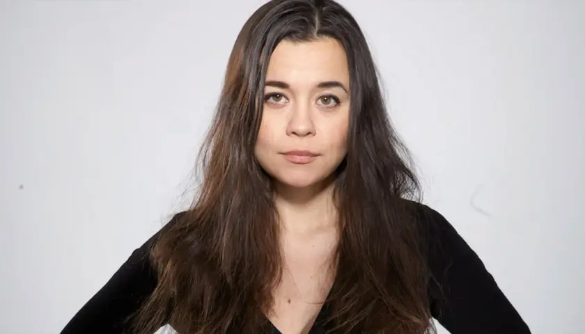 Caroline Ringskog Ferrada-Noli, med sitt långa mörka hår och blick som möter betraktaren, klädd i en svart topp.