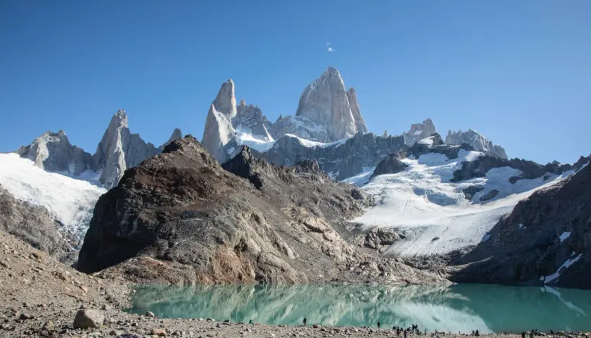 Majestätische Berge spiegeln sich in einem türkisfarbenen See. Die Szene vermittelt das Gefühl, dass dies die **Patagonien beste Reisezeit** ist, um diese atemberaubende Landschaft zu erleben.