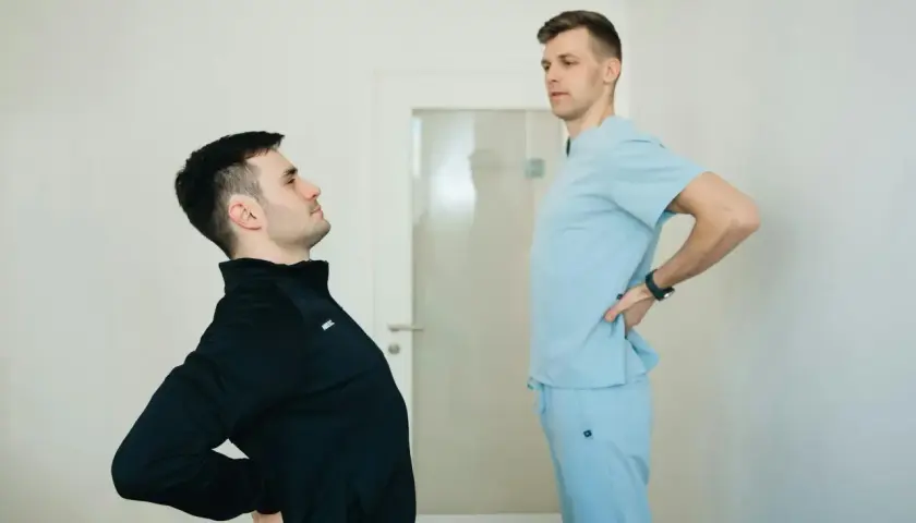 Fizjoterapeuta ocenia plecy okrągłe pacjenta.