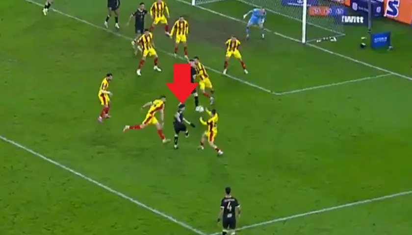 Intensywna akcja w meczu Pogoń Szczecin – Korona Kielce. Piłkarz w czarnym stroju próbuje odebrać piłkę zawodnikowi w żółto-czerwonych barwach.