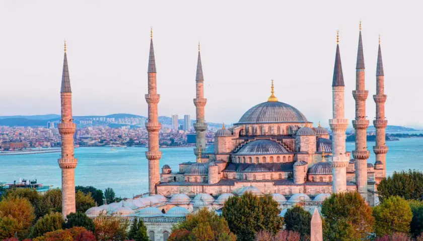 Impresionante mezquita con seis minaretes y cúpulas, bañada por la luz dorada del atardecer. Un paisaje de **estambul fotos bonitas** que te transporta a otra época.