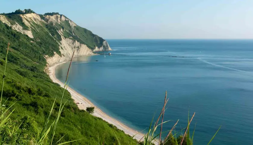 Vista panoramica della spiaggia di Mezzavalle, con scogliere verdi e mare azzurro. Le recensioni la descrivono come un paradiso.
