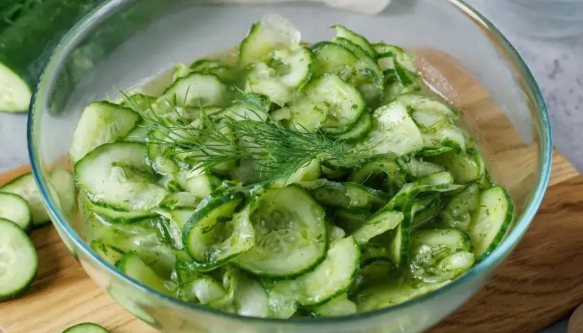 Frischer gurkensalat wie bei Oma, mit Dill garniert, in einer Glasschüssel.