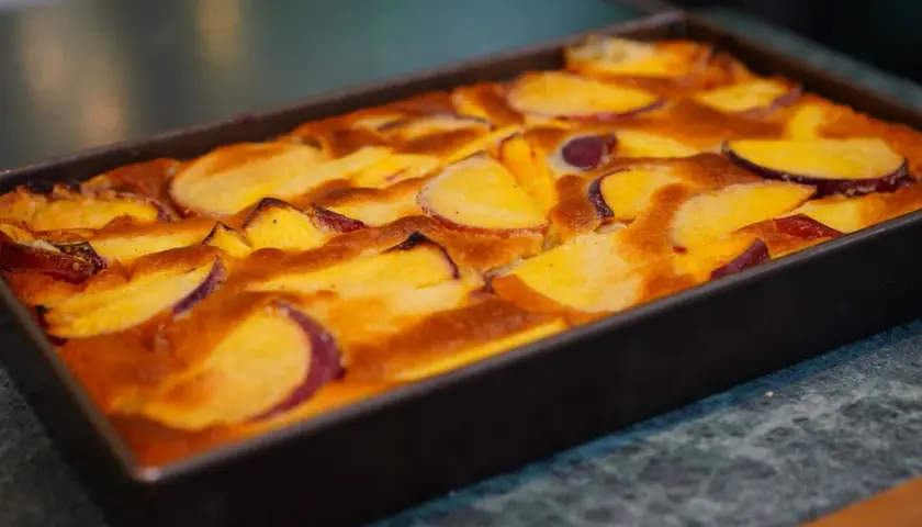 Clafoutis aux pêches dorées, tout juste sorti du four, prêt à être dégusté.