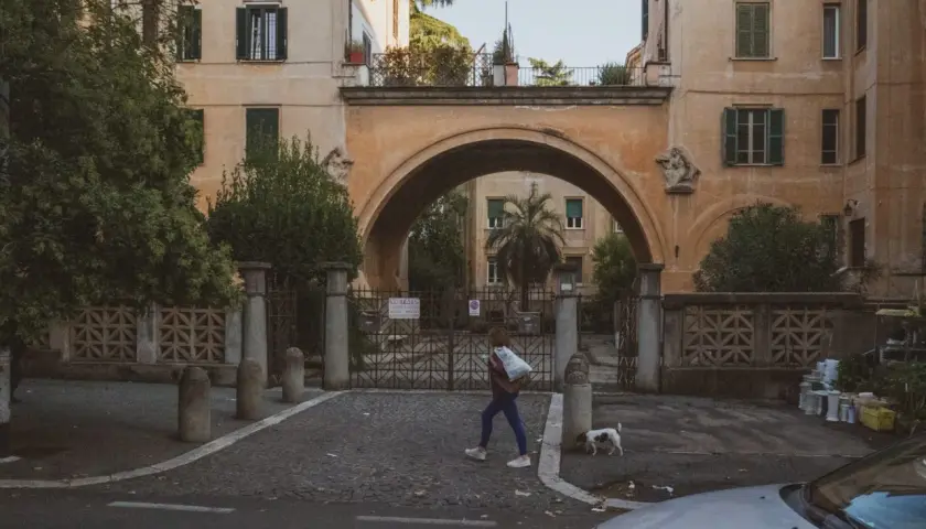 Una ragazza attraversa un arco a Montesacro, Roma. Scopri come arrivare in questo quartiere caratteristico.