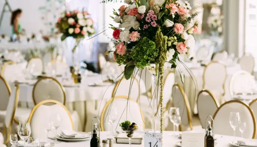Elegancka dekoracja stołu weselnego z bukietem kwiatów i numerem 14. Sprawdź wedding planner cena, by zorganizować wymarzone przyjęcie.
