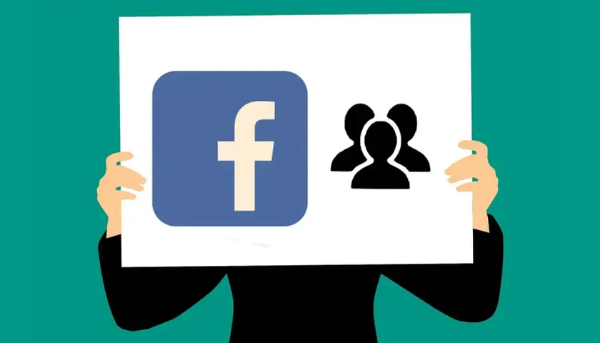 Logo Facebook i ikona grupy ludzi na plakacie. Ktoś trzyma go, prezentując się jako lider wśród fanów.