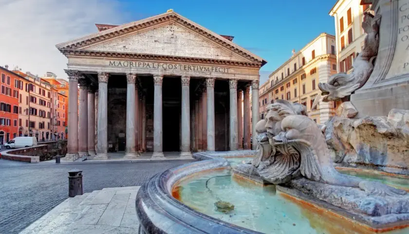 Fontana di Piazza della Rotonda Pantheon, con le sue sculture di delfini e volti, riflette la maestosità dell'edificio antico.