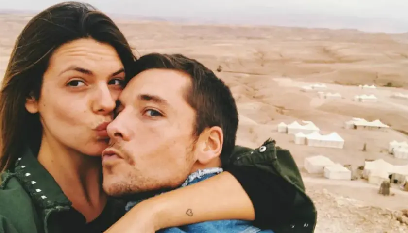 Laura Matamoros y Benji se dan un tierno beso en un paisaje desértico con tiendas de campaña.
