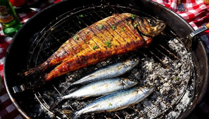 Poisson grillé et sardines sur un barbecue. Faut-il écailler les sardines avant de les griller ? La réponse est dans l'image.