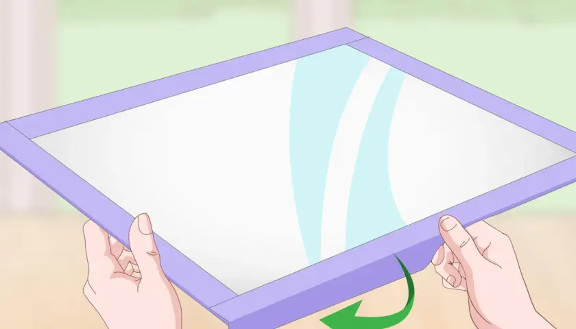 Manos sujetan un marco morado alrededor de una superficie blanca, mostrando cómo hacer una pizarra casera.