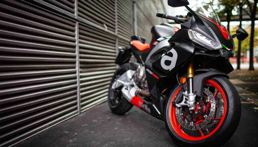 Aprilia RS 660, una moto deportiva negra con detalles rojos y naranjas, lista para la acción.