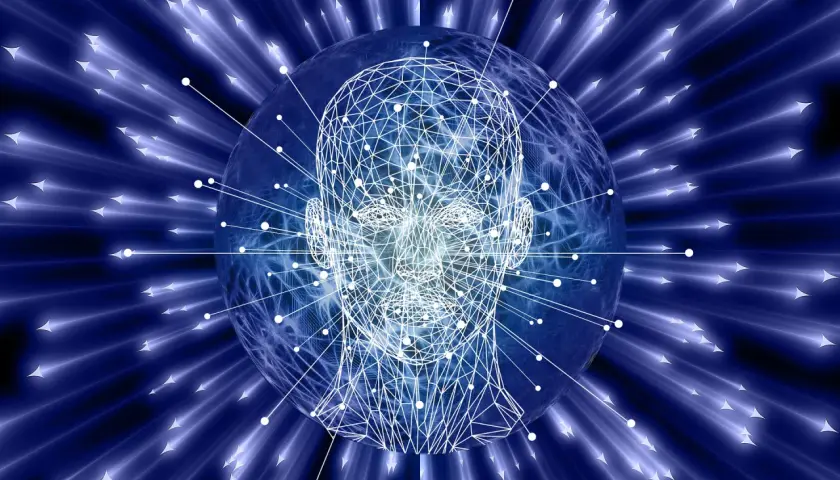 Tête humaine filaire sur une sphère bleue, entourée de rayons lumineux bleus et de flèches. Le fichier yml de l'IA est prêt.