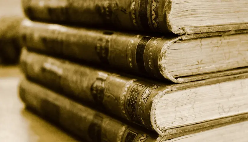 Stapel alter Bücher, die wie Henner, Rudi und Rosa in einer Reihe stehen.