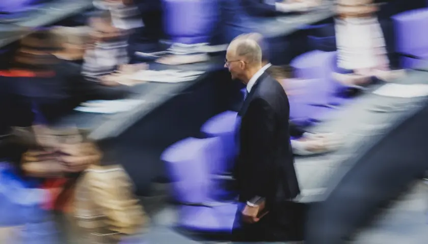 Mann im Anzug geht durch den Bundestag. Wer darf Bundeskanzler werden? Die Frage beschäftigt viele.
