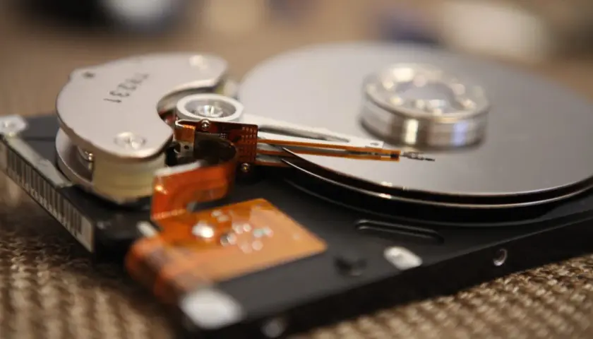 Nahaufnahme einer geöffneten Festplatte, die zeigt, wie die Lese-/Schreibköpfe über die Spindeln gleiten. Dies ist ein Beispiel für die Technologie, die früher für die Datenverwaltung verwendet wurde, bevor SSDs mit TRIM-Funktion aufkamen.