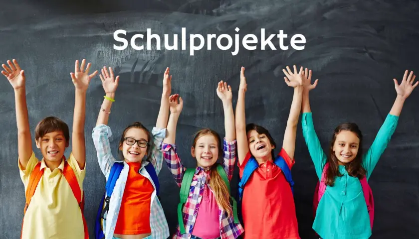 Fünf Kinder mit Rucksäcken und erhobenen Armen vor einer Tafel, die "Schulprojekte" anzeigt.