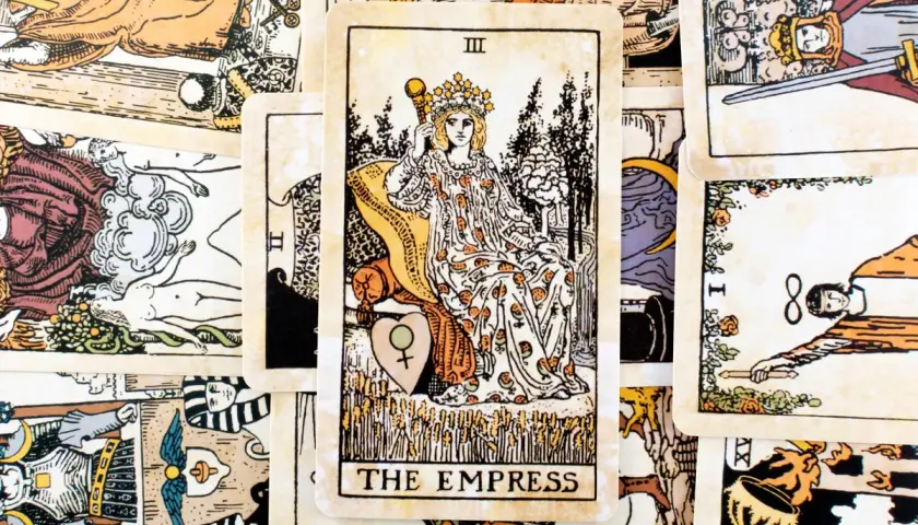 Centralna karta tarota to Cesarzowa (The Empress) III, otoczona innymi kartami.