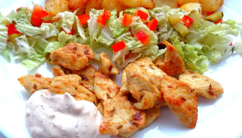 Pyszna shoarma z kurczaka z chrupiącymi ziemniaczkami, świeżą sałatką i kremowym sosem. Idealny posiłek na szybki obiad.