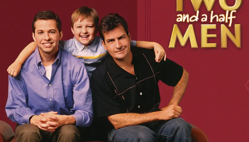 Charlie, Alan i Jake z serialu "Dwóch i pół" siedzą razem, uśmiechnięci.