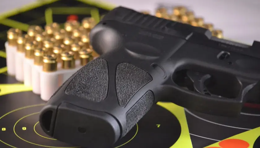 Pistolet i amunicja na tarczach strzeleckich, symbolizujące pozwolenie na broń do ochrony osobistej.