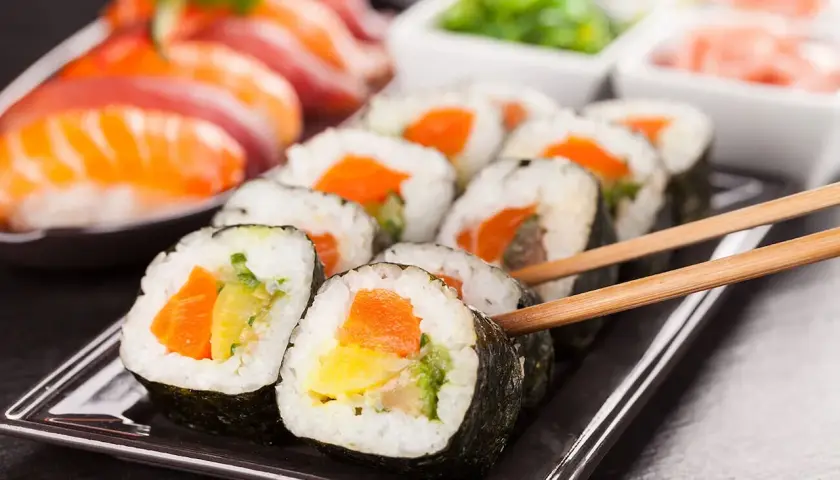 Roladki sushi z łososiem i warzywami, gotowe do jedzenia. Idealny ryż do sushi to podstawa smacznego posiłku.