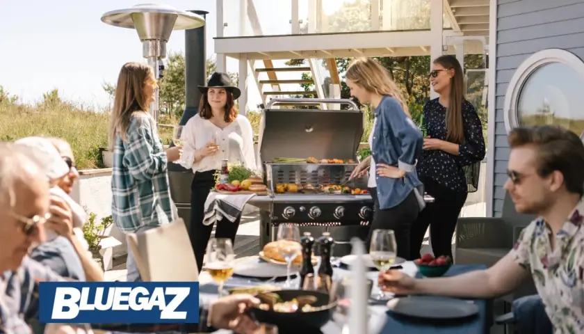 People enjoying a barbecue on a sunny patio with a Bluegaz Z1 grill.