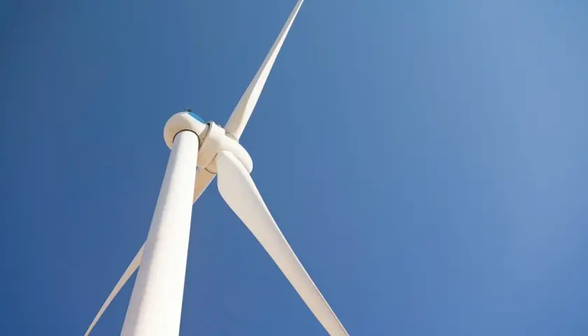 Biała turbina wiatrowa bez pozwolenia na tle błękitnego nieba.