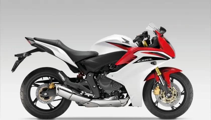 Sportowy motocykl Honda CBR600F w białej i czerwonej kolorystyce, gotowy do dynamicznej jazdy.