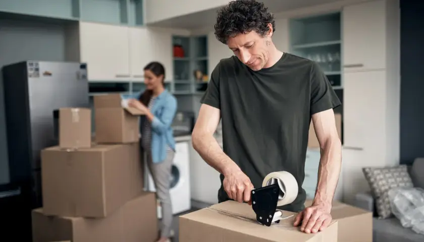 Mann packt Kartons für den Umzug. Bald wird er die umzugskosten steuerlich absetzen können.