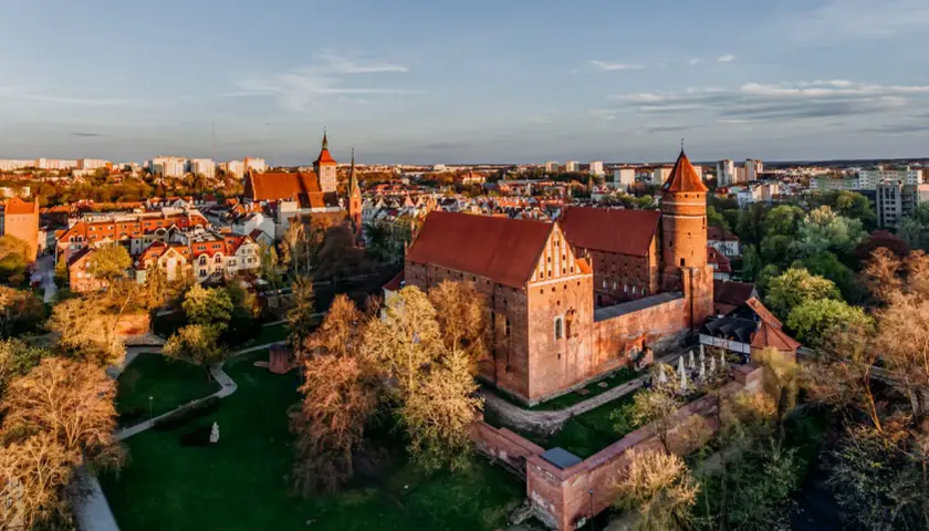 Zamek w Malborku, gdzie kiedyś rezydowali krzyżacy, w blasku zachodzącego słońca.