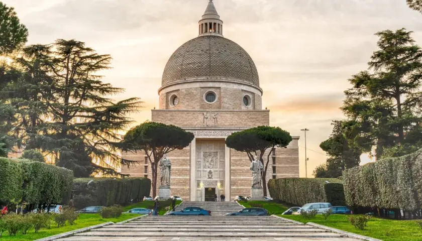 Basilica di San Pietro e Paolo a Roma, con la sua imponente cupola e statue, circondata da alberi e giardini curati.