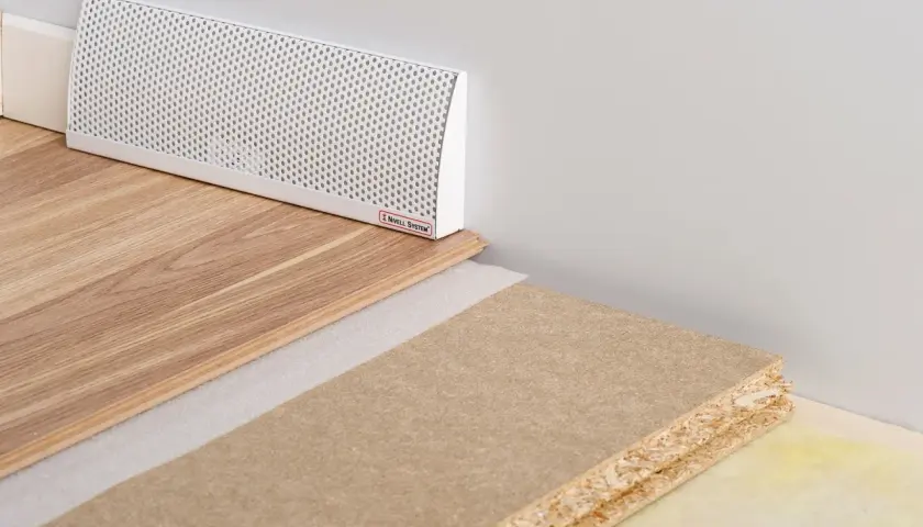 En vit ventilationsgaller för ett passivt ventilerat golv, med trägolv och byggmaterial.