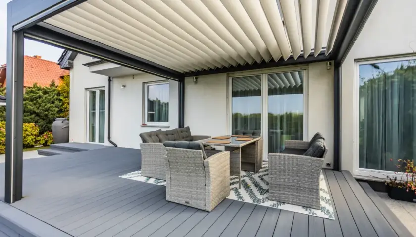 Nowoczesna pergola z meblami wypoczynkowymi na tarasie. Czy zabudowa tarasu wymaga pozwolenia na budowę?