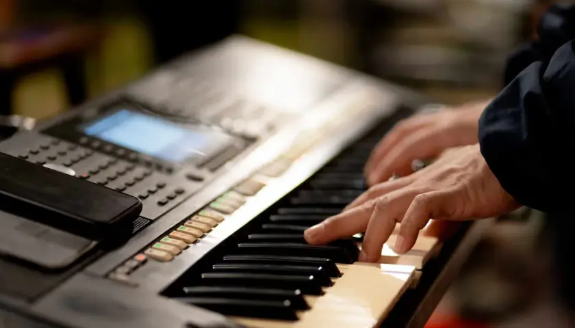Dłonie grające na keyboardzie, tworząc muzykę. To jest keyboard.