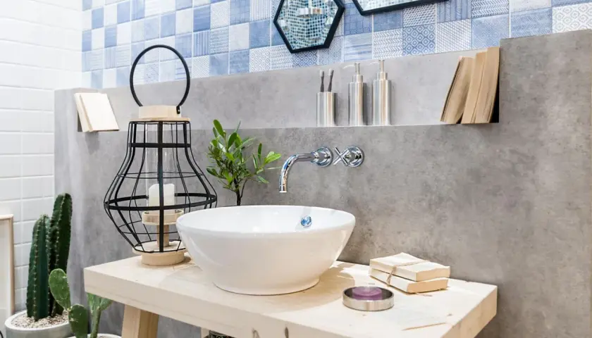 Bad Deko Ideen: Waschbecken mit Kaktus, Laterne und Büchern. Blaue Fliesen und Betonwand.