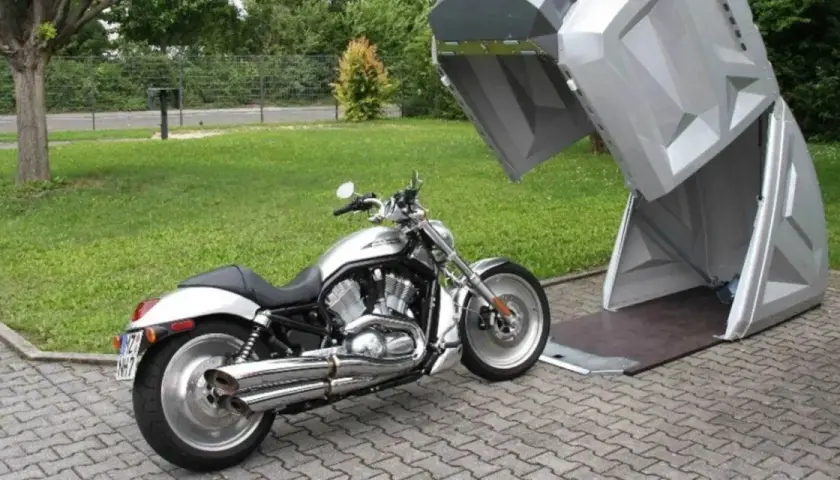 Srebrny motocykl czeka na schowanie w nowoczesnym, otwartym stojaku na skuter.